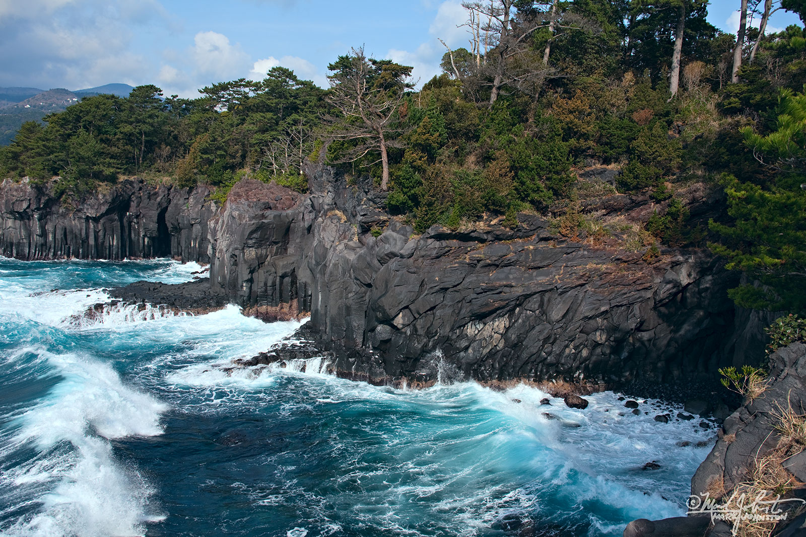 Waves crashing into the Jyogasaki Coast, Izu Penninsula, Shizuoka Prefecture, Japan. "Jyogasaki", written 城ヶ崎, means "next to the castle". The steep cliffs are composed of columnar basalt that forms when lava cools at a relatively slow pace, allowing regular contraction fractures to form. These cliffs resemble the stone walls of Japanese castles.