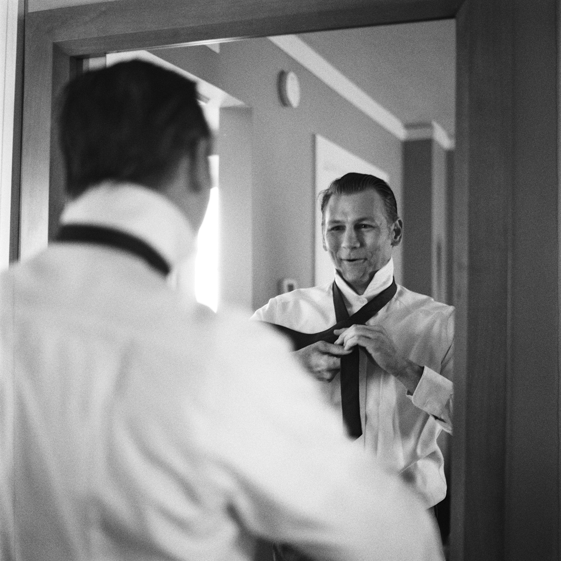 167-groom-finishing-his-tie-and-opening-a-wedding-gift-in-downtown-seattle.jpg