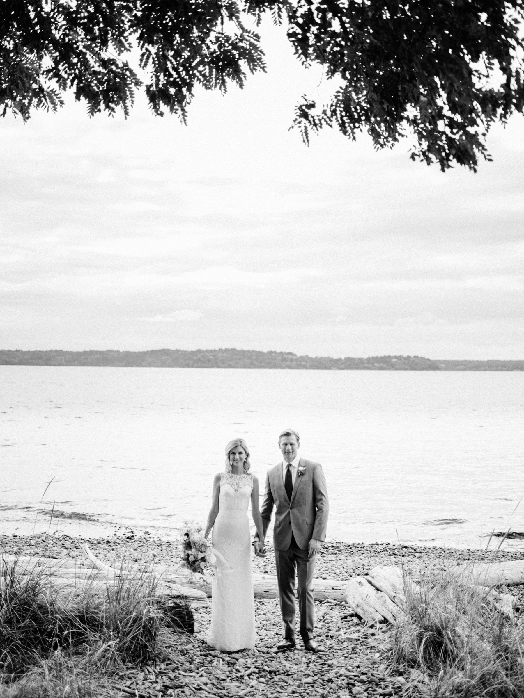 184-wedding-couple-walking-on-driftwood-holding-flowers-by-floret-floral.jpg