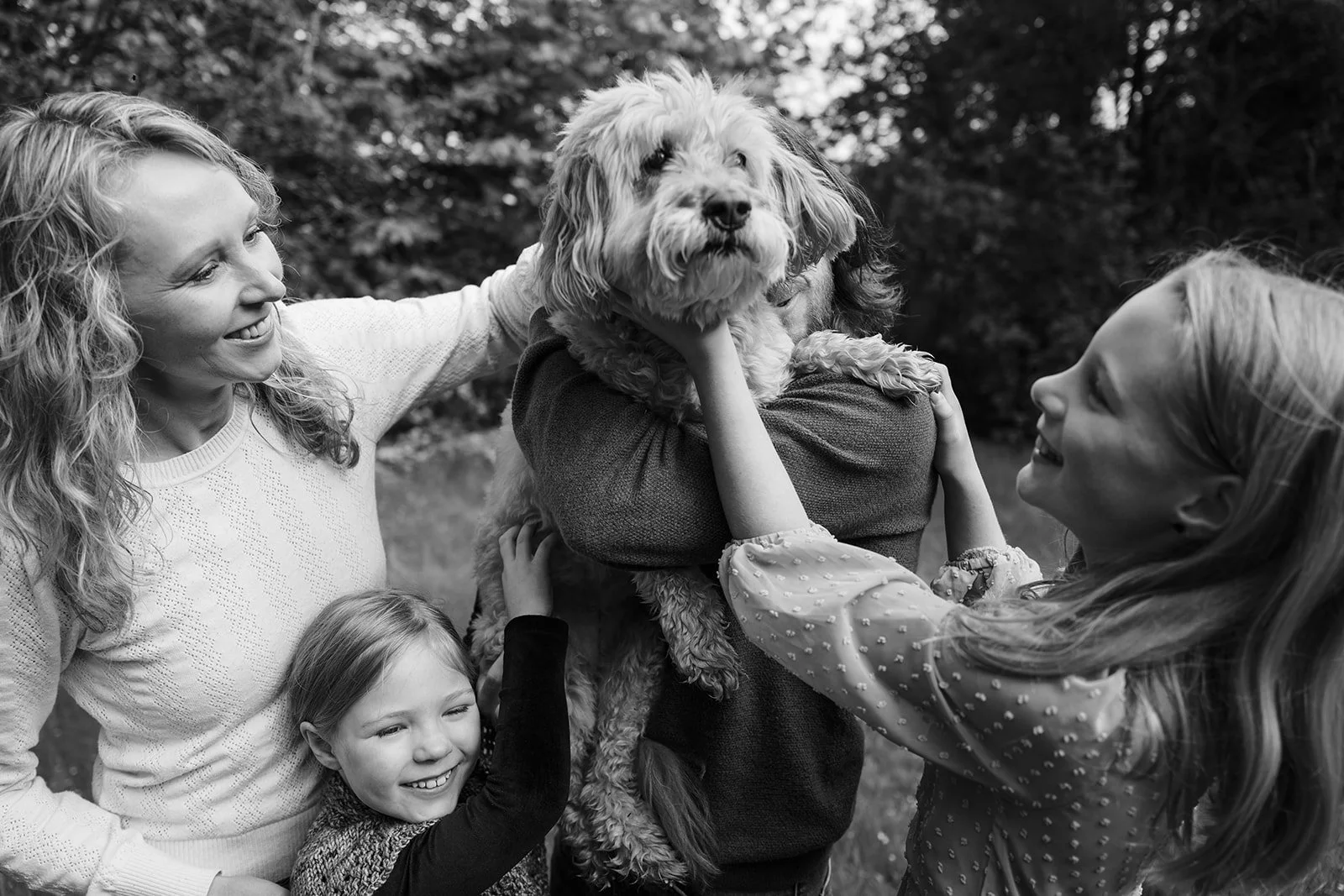 a family photo with a dog at Seward Park in Seattle by Seattle Family photographer Ryan Flynn
