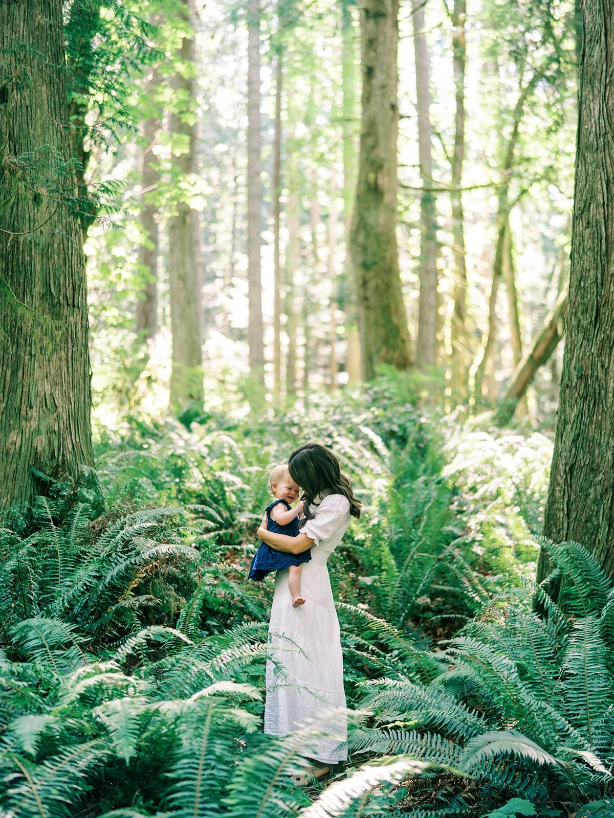 a unposed fine-art film editorial family portrait on Bainbridge Island in a lush forest, by Seattle Family photographer Ryan Flynn