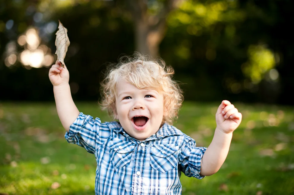 portrait-one-year-old-blonde-boy-smiling-holding-leaf-seattle.jpg