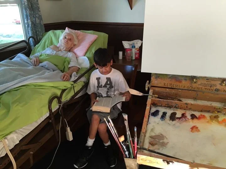 Cole reading the book of Genesis to Grandma as I prepare to paint.