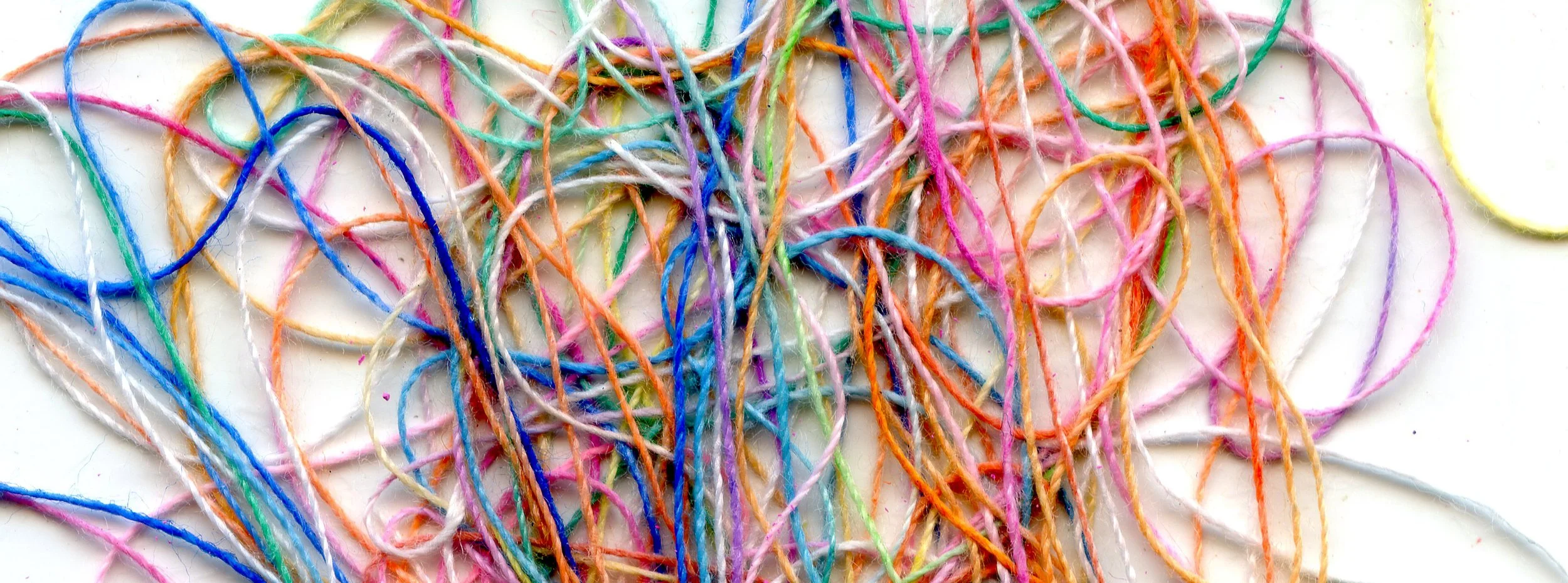 Photo illustration of colored string tangled together