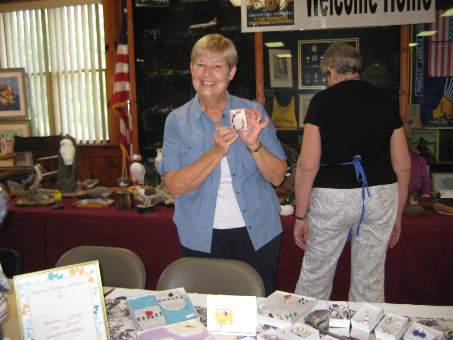  Eleanor Strietman shows off a handcrafted bejeweled watch sent by former-resident BJ McClaeb to exhibit at the Fair along with BJ's CDs.&nbsp; 