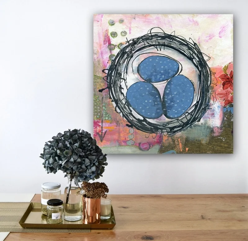 room view of nest painting hanging wall over a side table tray with flowers