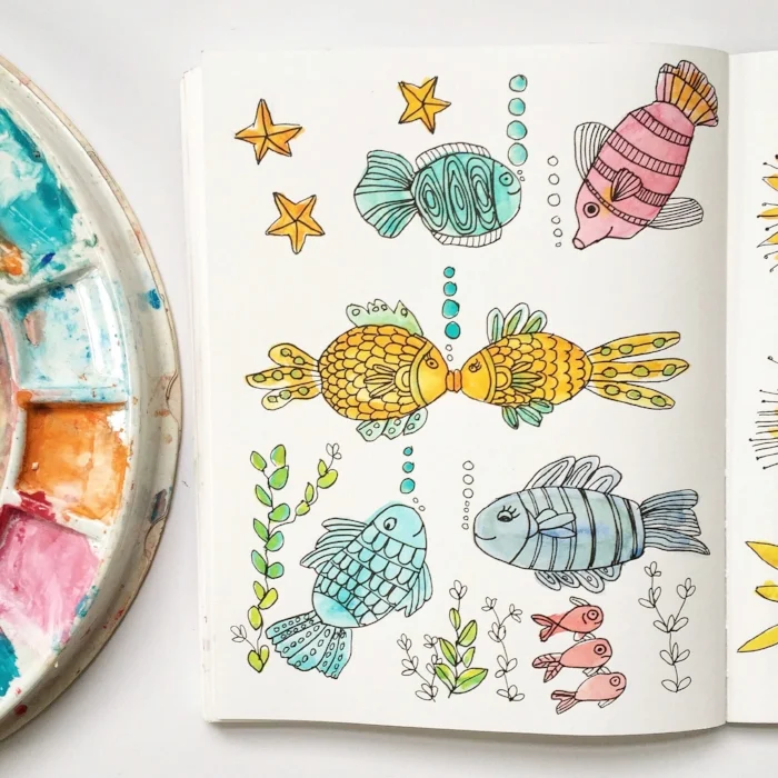 Cute fish watercolor drawings in sketchbook.