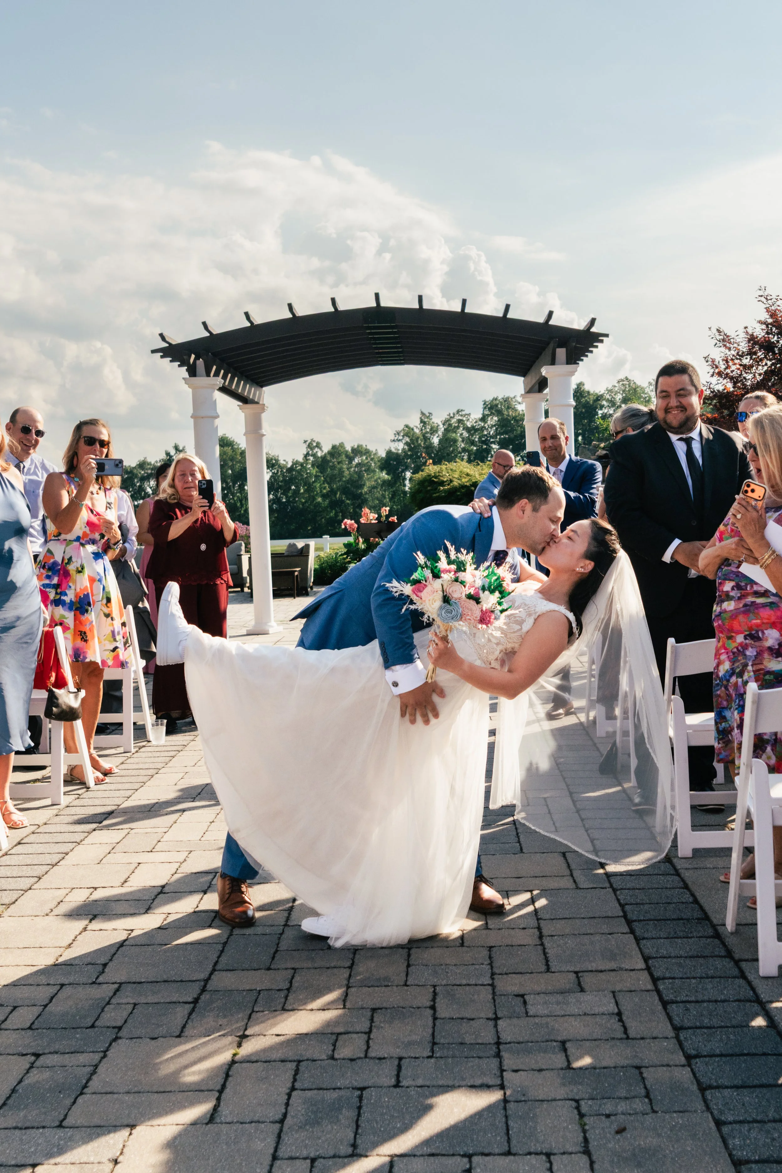 A groom dips and kisses his bride after just getting married during their wedding at Four Oaks Country Club in Dracut, MA.
