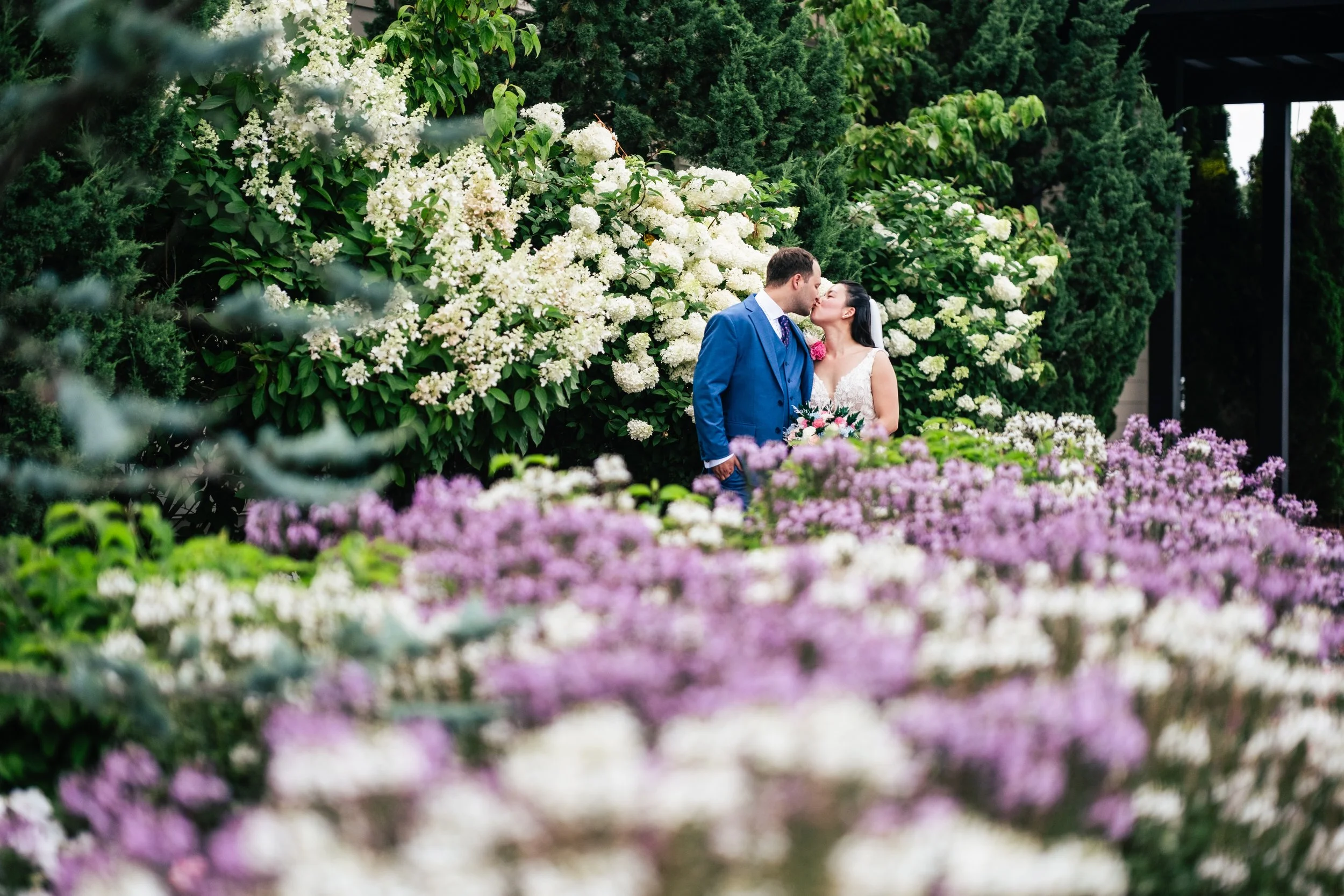 A bride and groom kiss for a portrait during their wedding at Four Oaks Country Club in Dracut, MA.