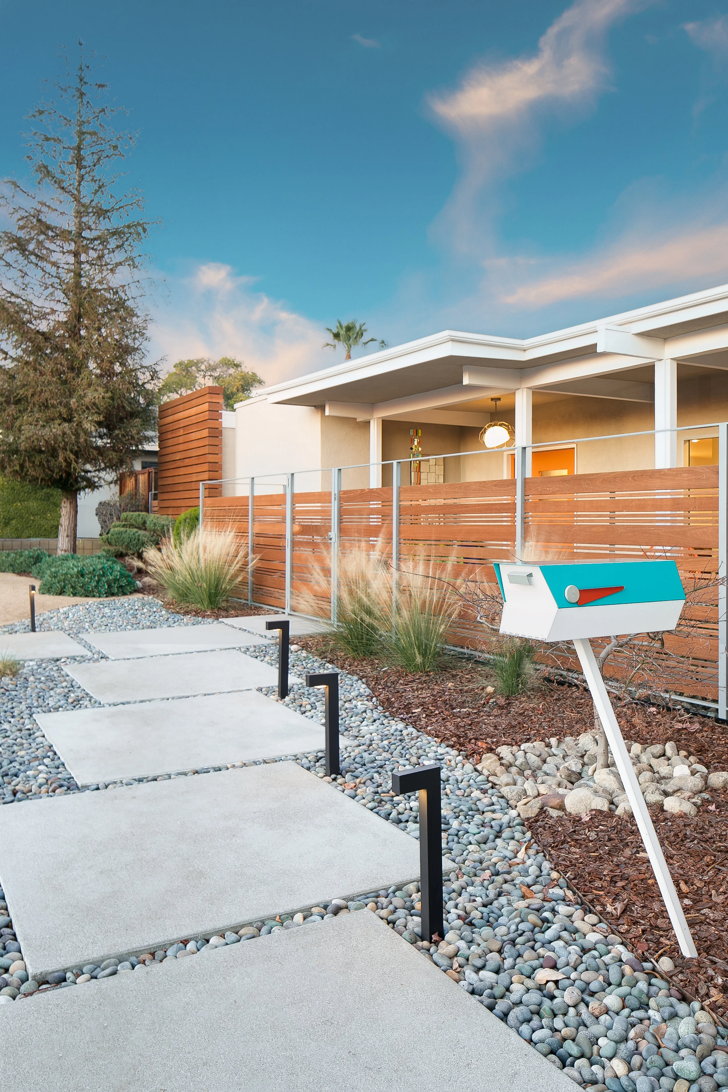 The landscaping and new pathway are accented by the wood and metal fence, extending the home with a private courtyard