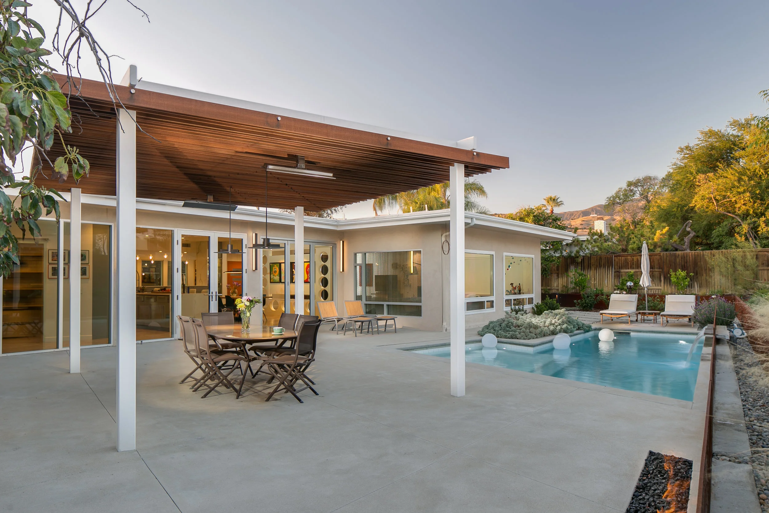 This backyard features custom pool, fire pit, pergola and spillways