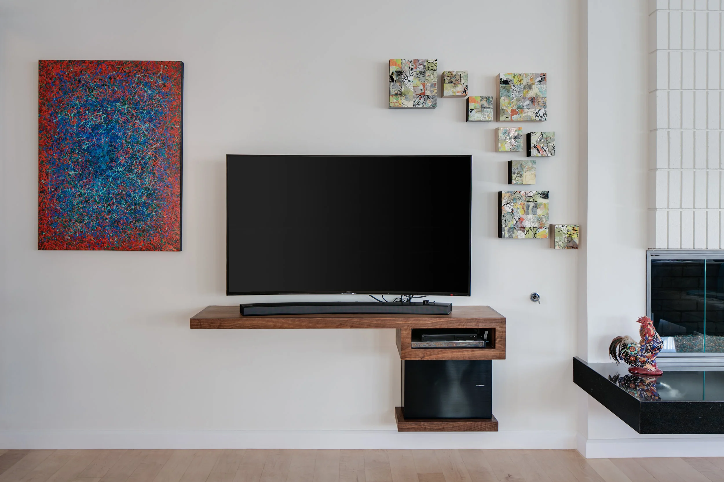The floating walnut TV stand in the living room is a counter point to the floating fireplace hearth