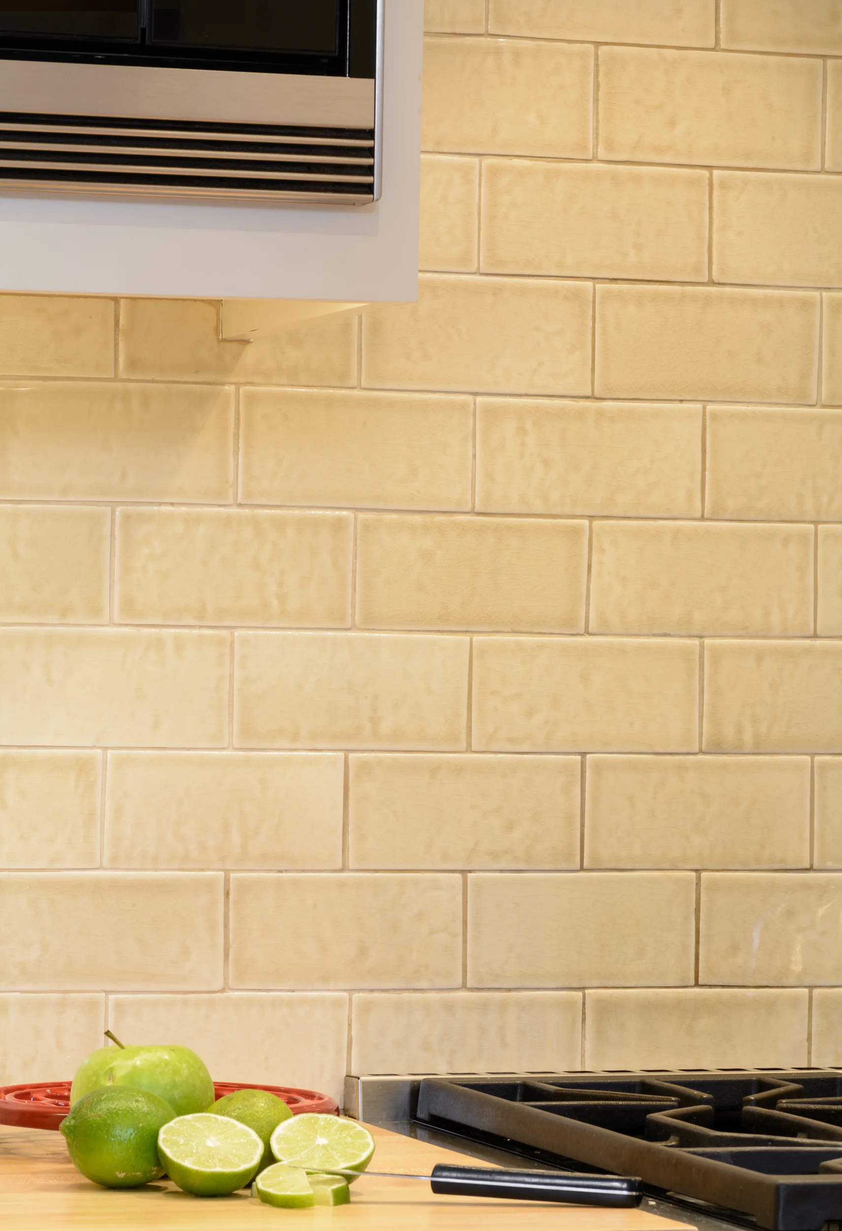 Warm and soft color palette for the tile backsplash and wood chopping countertop