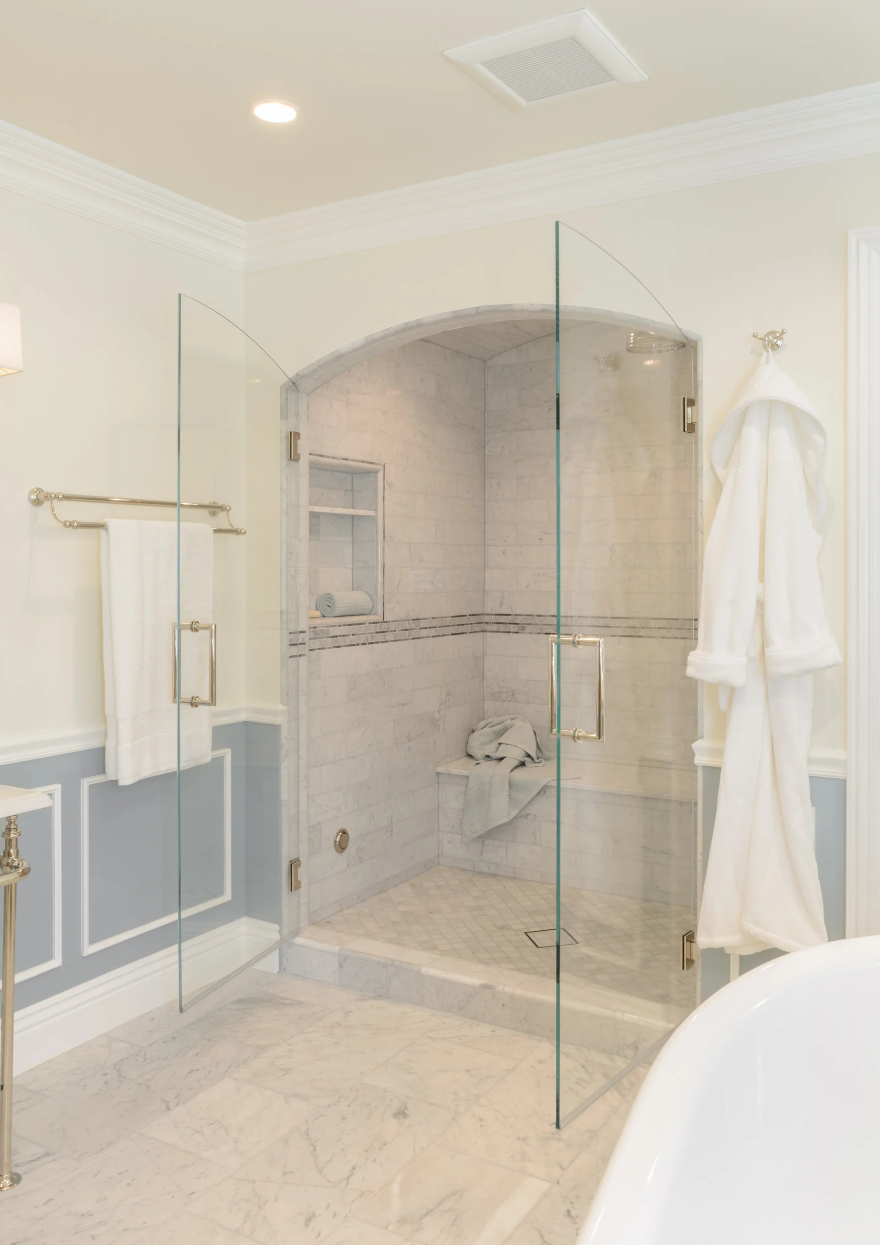 Low threshold shower alcove with frameless glass French swing shower doors
