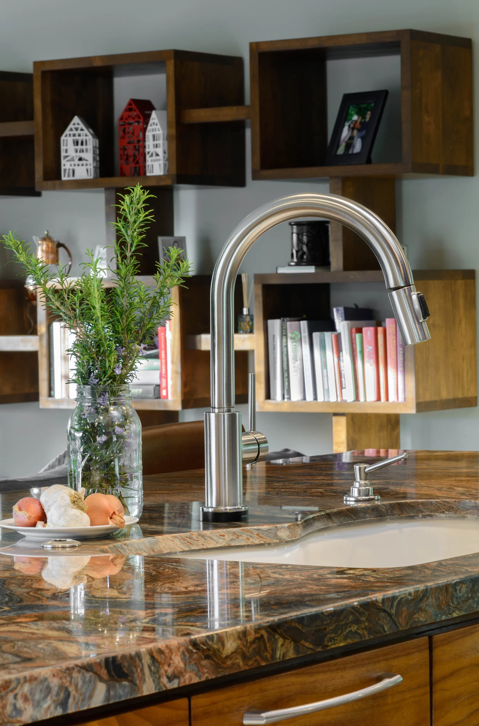 Island sink combined with a contemporary single-hole deck-mounted gooseneck faucet and a built-in soap dispenser