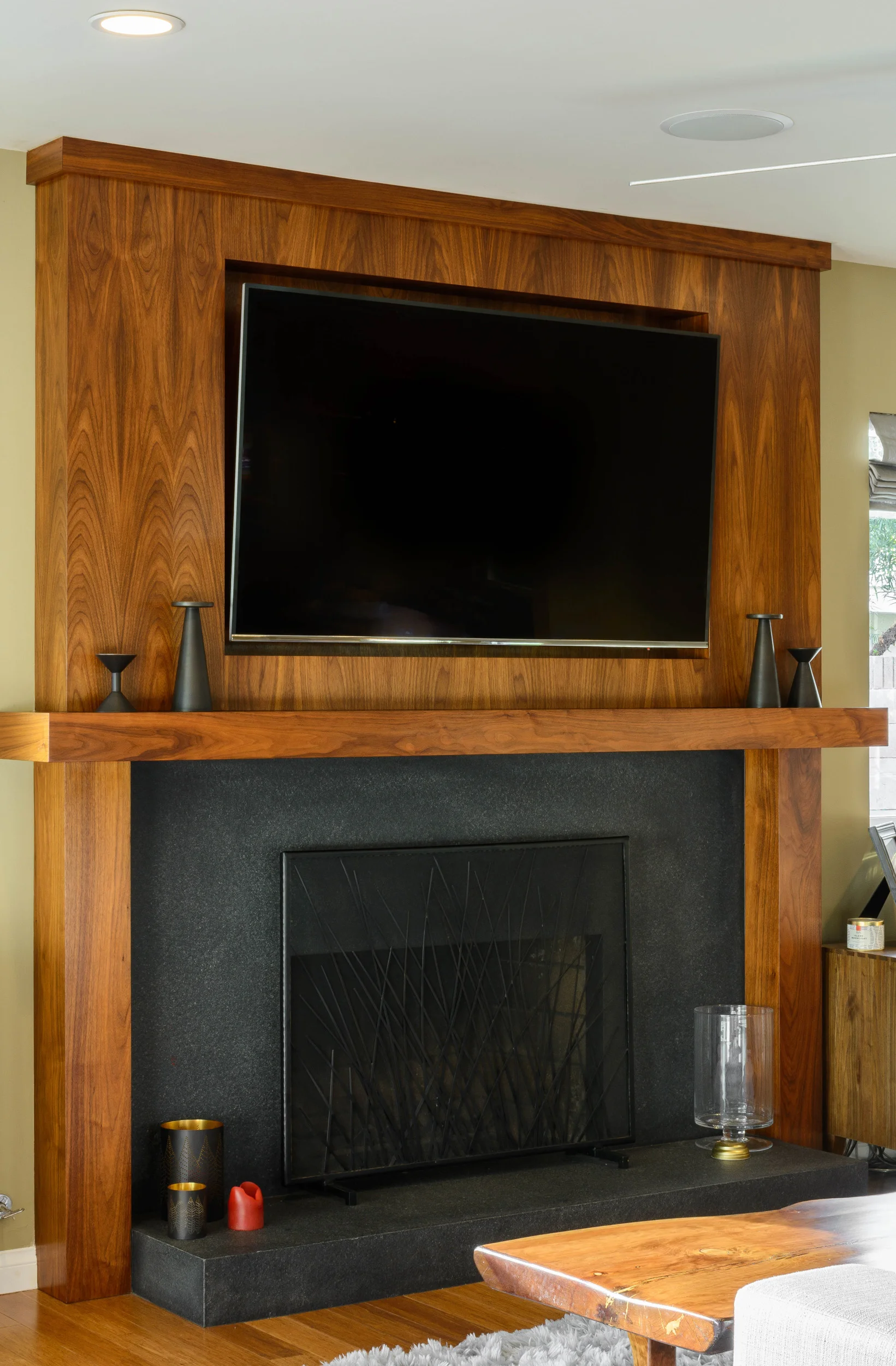 Fireplace with a stone hearth and custom-built walnut surround