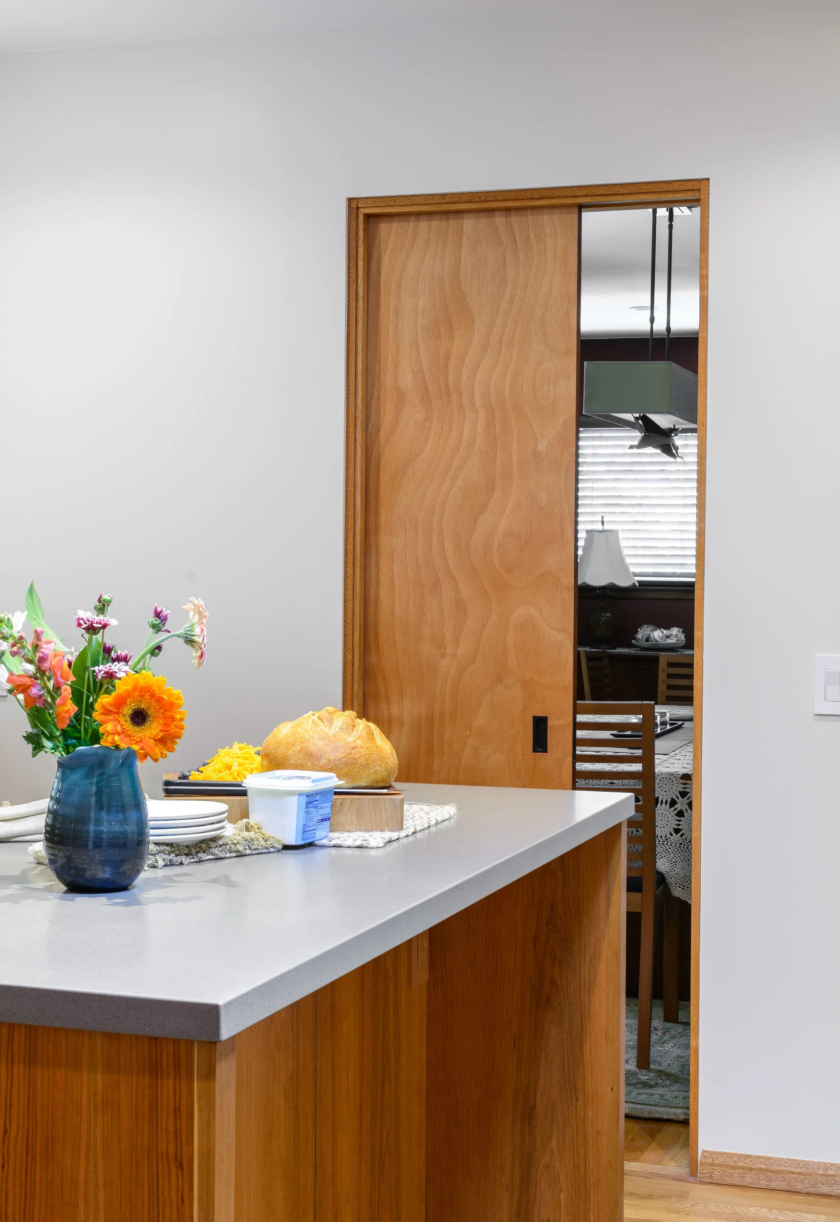 Kitchen pocket door in cherry wood between kitchen island and dining room