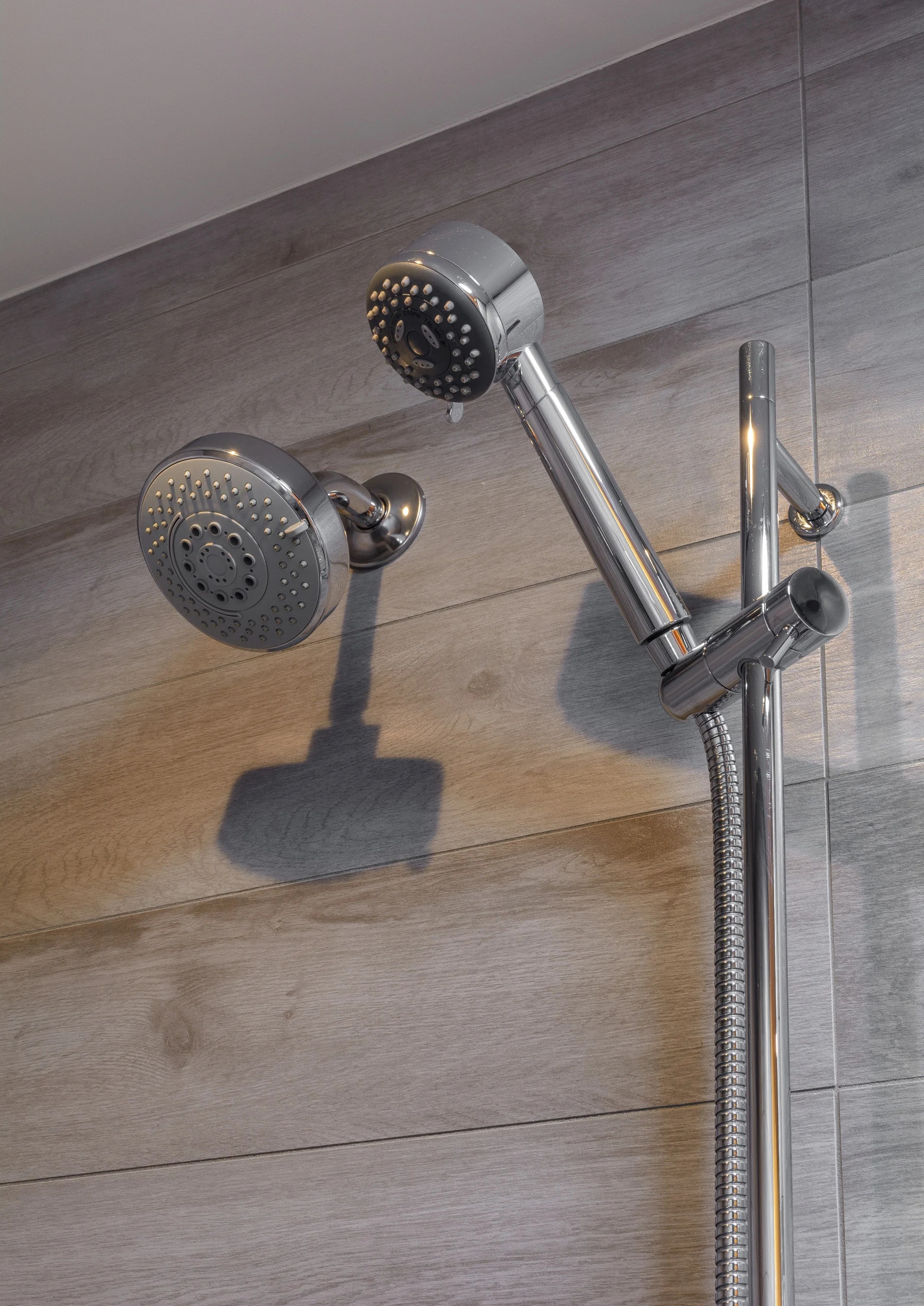 Rain and hand held shower fixture set mounted on a stacked weathered tile pattern