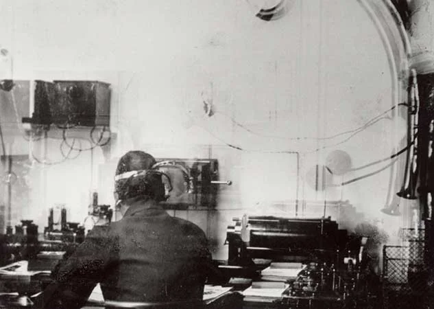 The only known photograph of Titanic's wireless room. The operator is most likely Harold Bride aged 21.