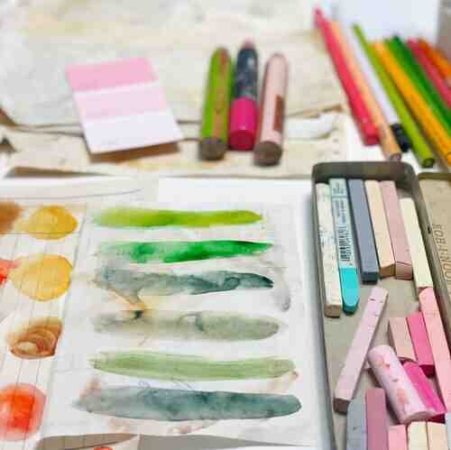 Assorted art supplies and watercolor papers 