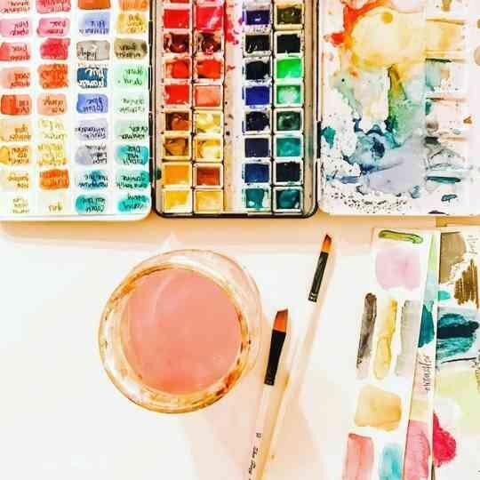 Watercolor palette with water jar and paint brushes
