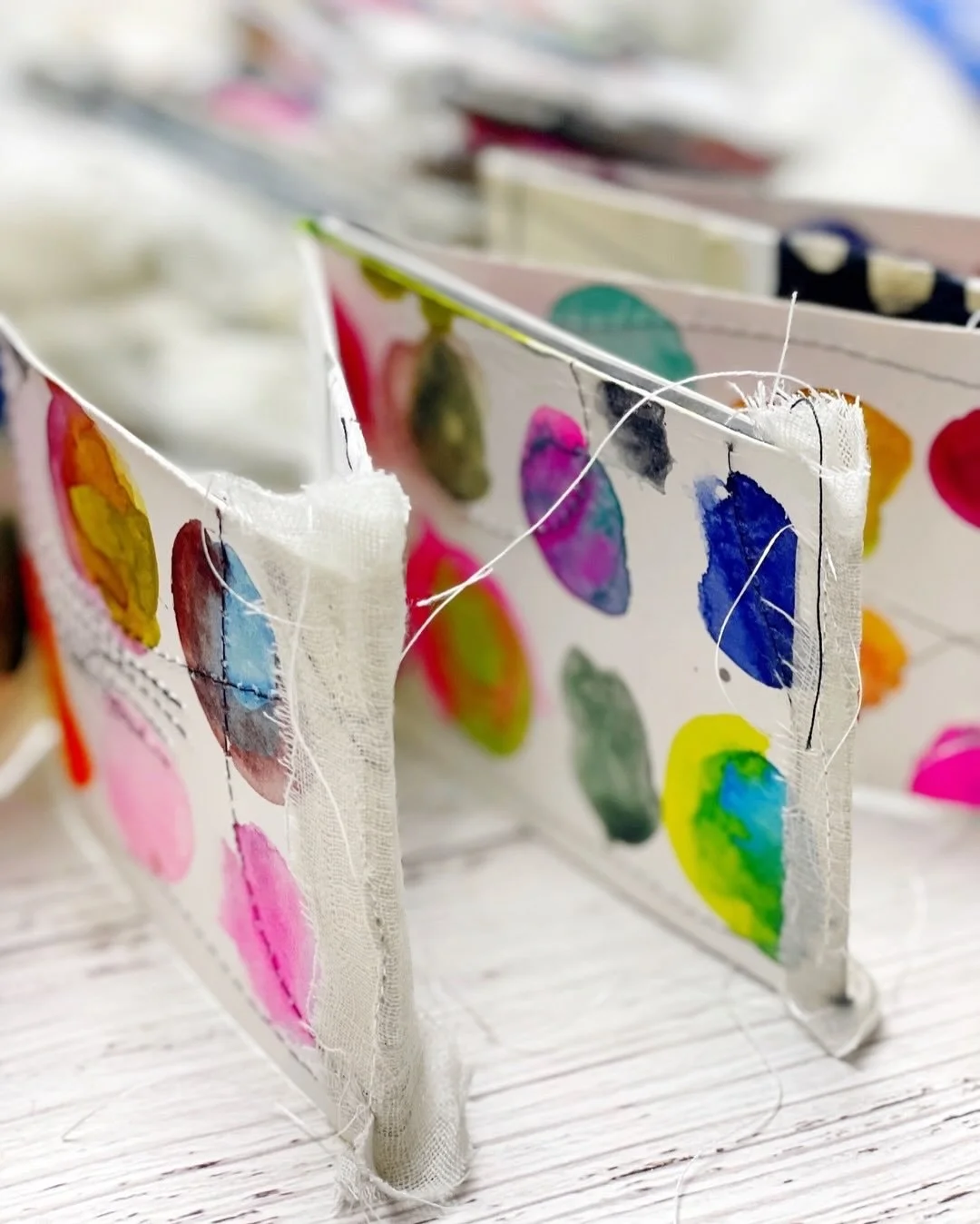 Colorful handmade watercolor concertina book with circle swatches. Stitched with fabrics and collaged with papers. Letting past projects inspire new ones. 😊 ❤️