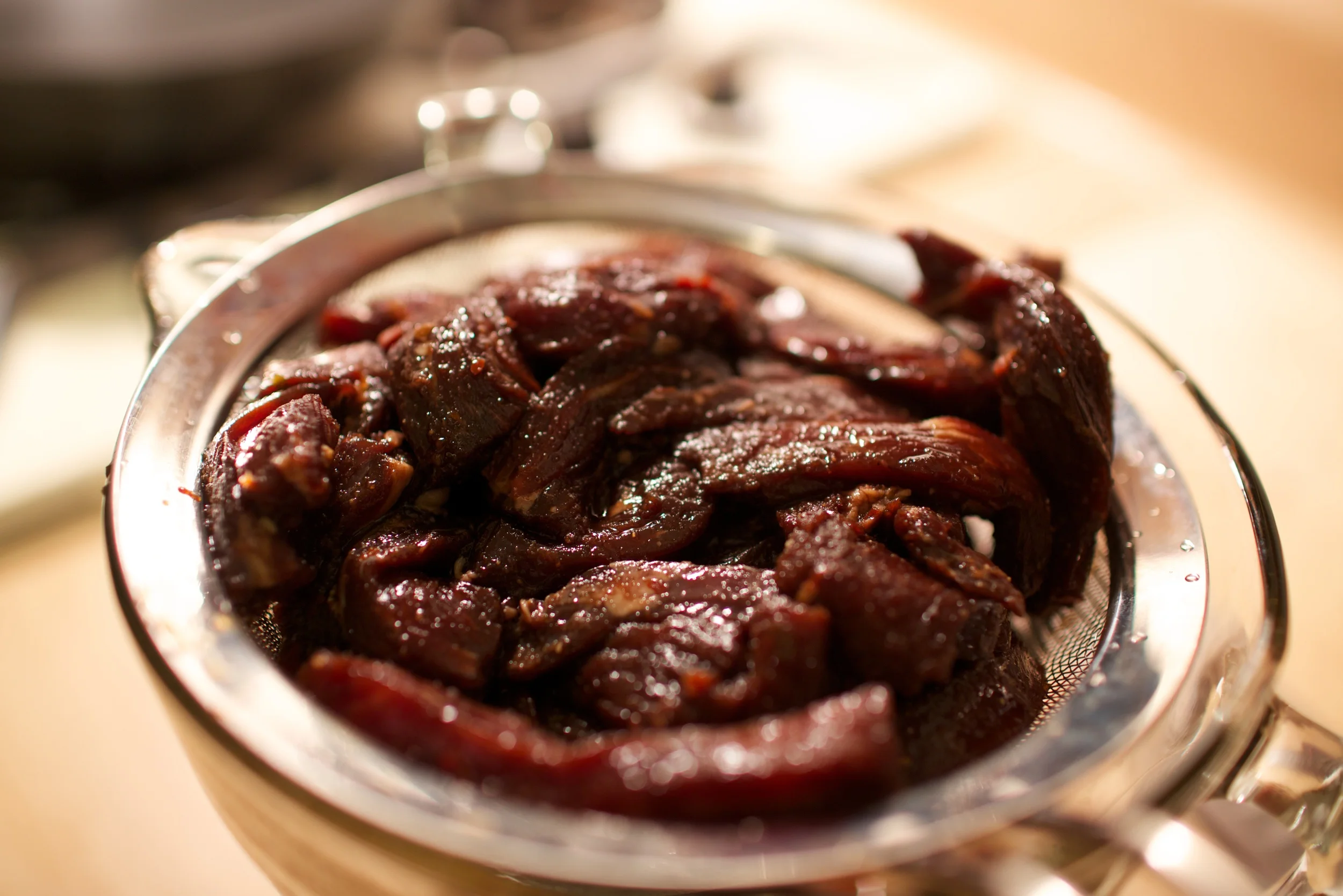 Removing the excess marinade via a colander.