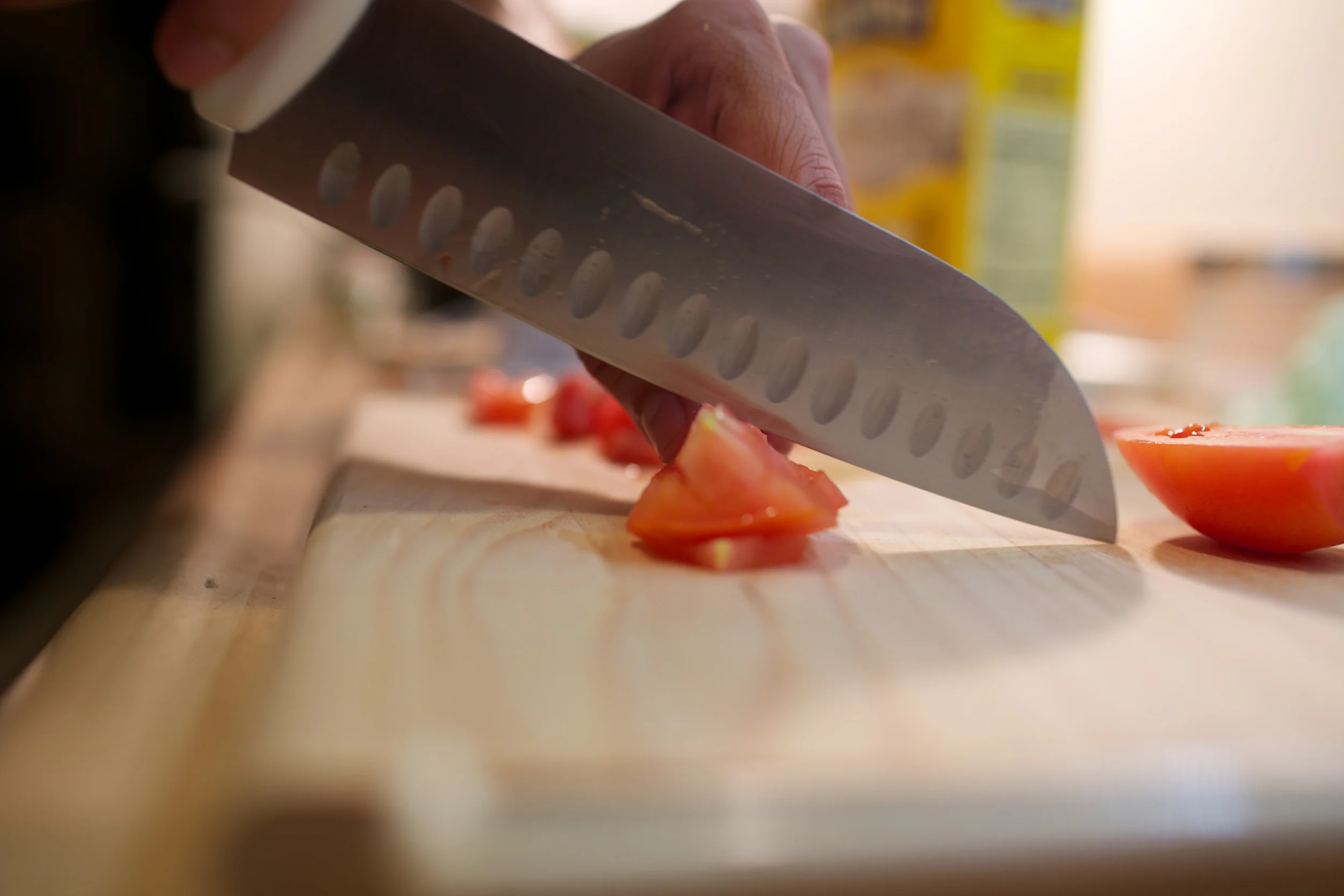 Kunal slicing tomatos, and hopefully not a finger.