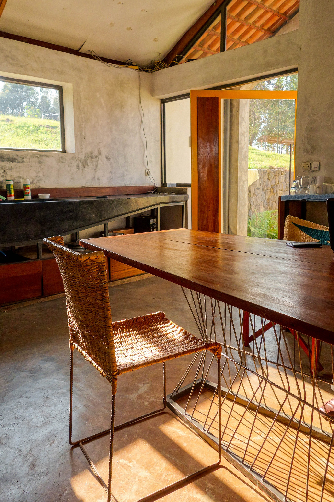 Likewise, all interior furnishings are custom-fabricated: the cypress and pine furniture, poured-in-place concrete sinks, metal light fixtures, as well as artisan-made doors, crafted with angled pieces leftover from the muvura wood roof trusses.