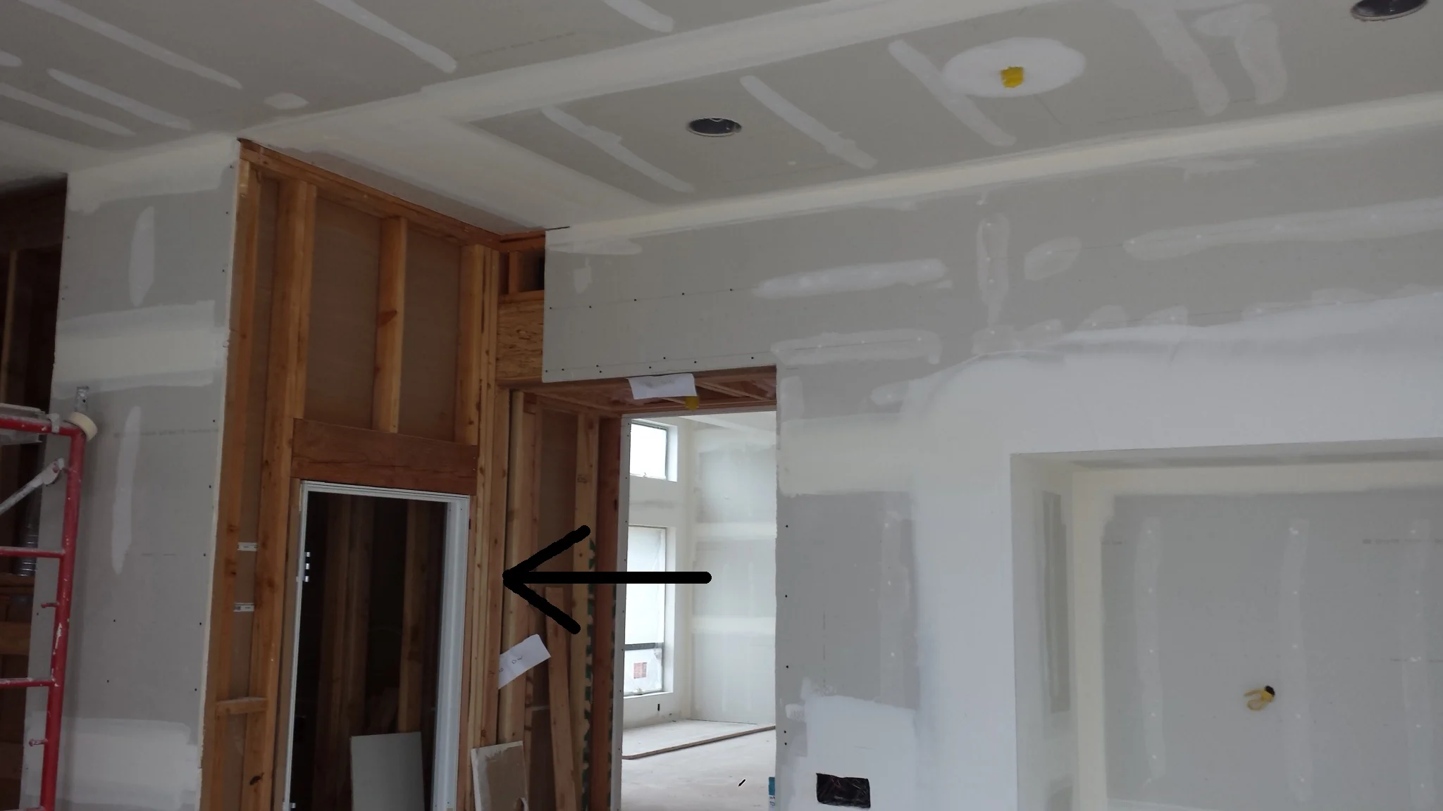 The black arrow is the slot (pocket) for the pocket door. This is one of three in this project. Note that the door is not yet installed. The track was installed during the framing. The measurements for the door are taken after framing is complete. On the plans, all three doors are four feet wide and 8 feet tall. In reality, all are unique to their opening. All must be specifically ordered and custom made for their respective opening. This one was 3'-10 7/8" x 8'-7/8".
