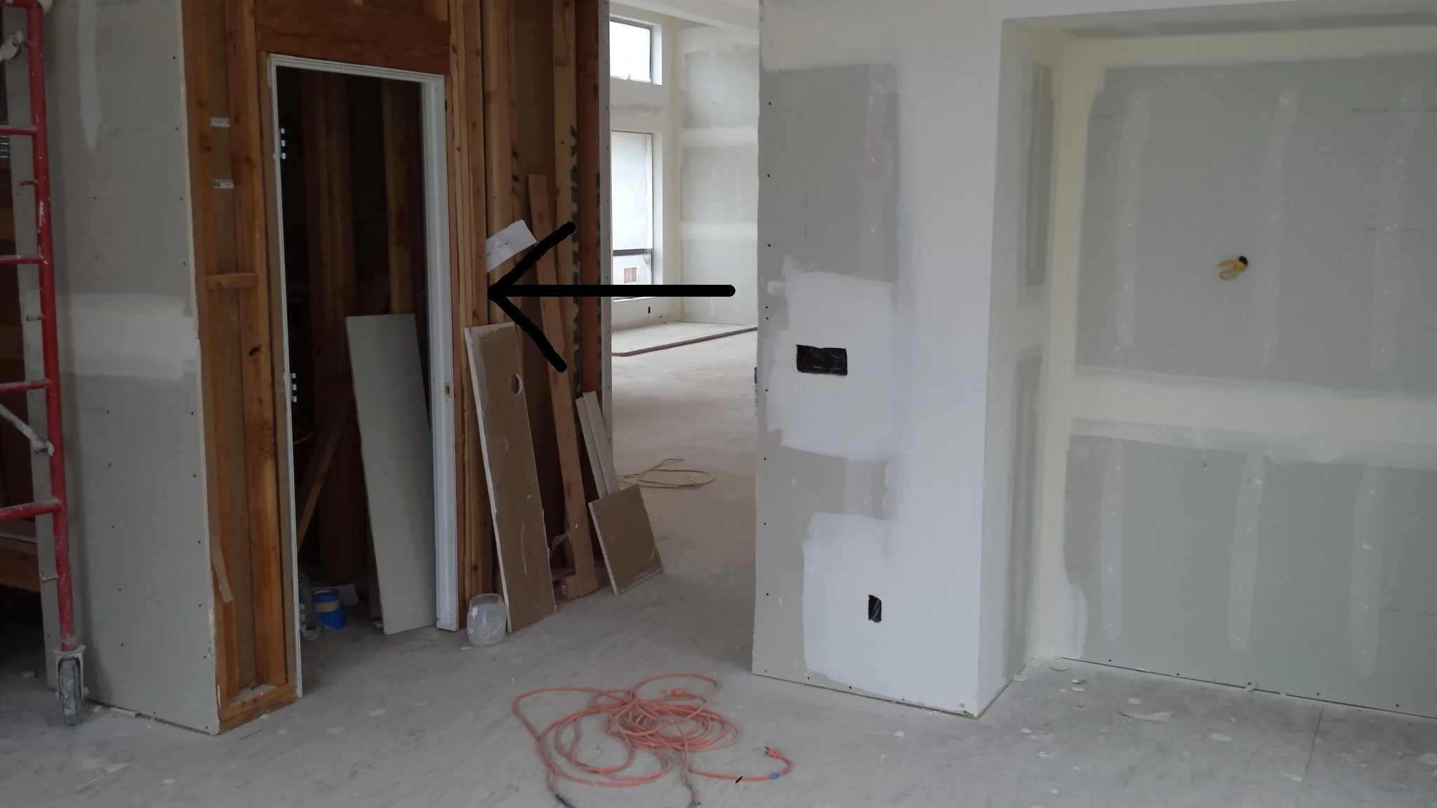 It is much easier to hang the doors without any drywall. However, to keep construction moving forward, the drywall is left off around the openings. After the door(s) is hung, the drywall will be finished up to the door opening.