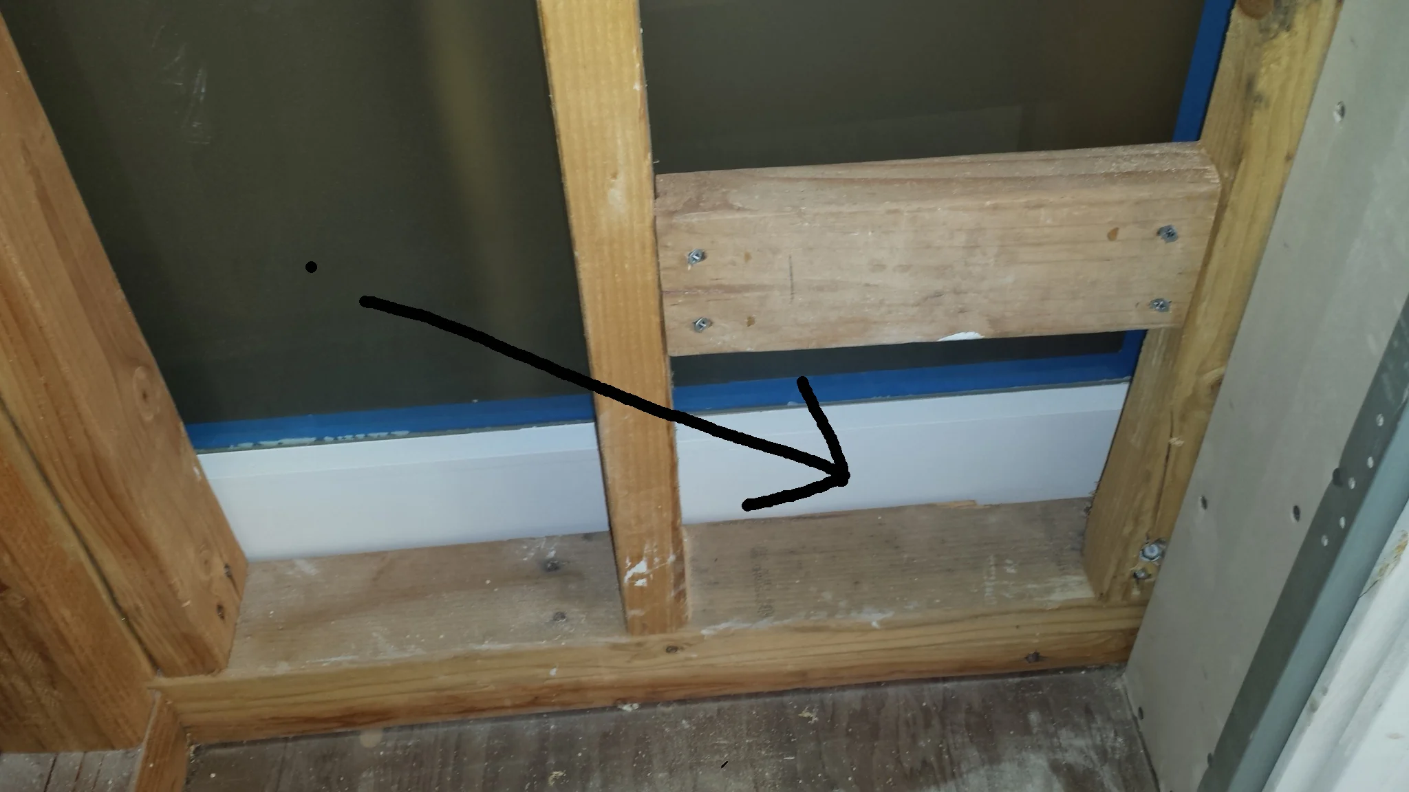 The black arrow, above, is pointing to an access door that will enable future adjustments to the door's hardware. The door will have a painted plywood cover on it eventually. This door is inside a closet. These access doors allow the door to be easily adjusted. Without these doors, it is not easy (if not impossible) to adjust the doors. When ever possible, these access doors should be planned at locations that aren't ready visible (such as a closet).