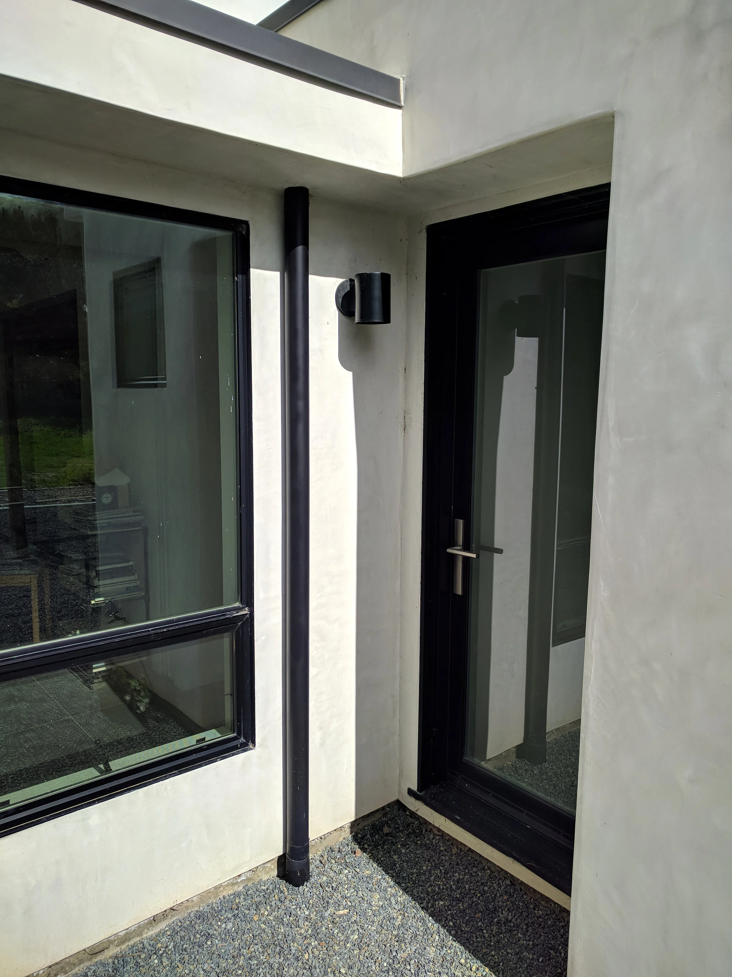 Downspout sits tight against house. Clean and clutter free.