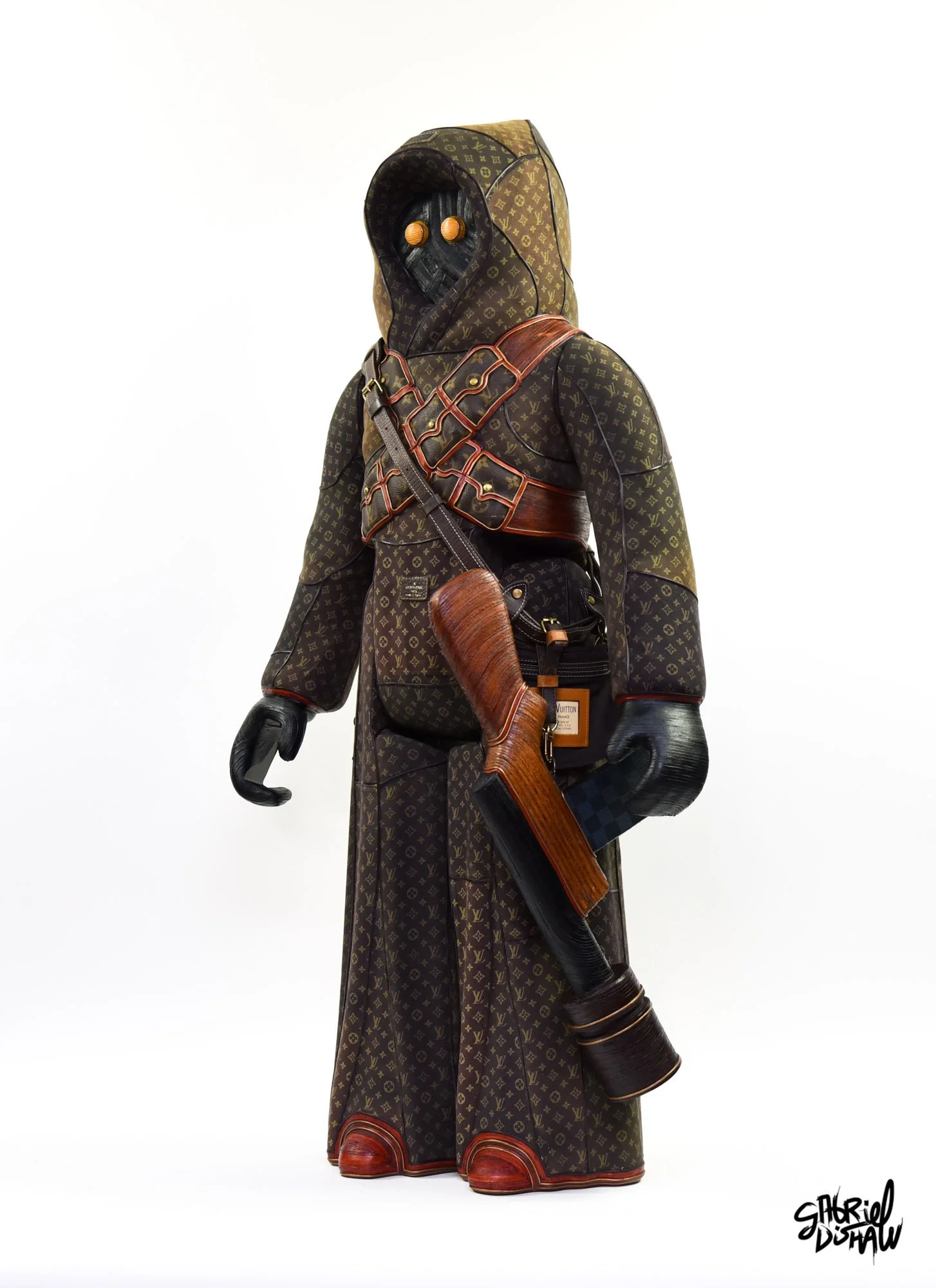 Life-sized Jawa sculpture in a hooded robe made from Louis Vuitton monogram canvas, with glowing amber eyes, a leather bandolier, and a custom blaster