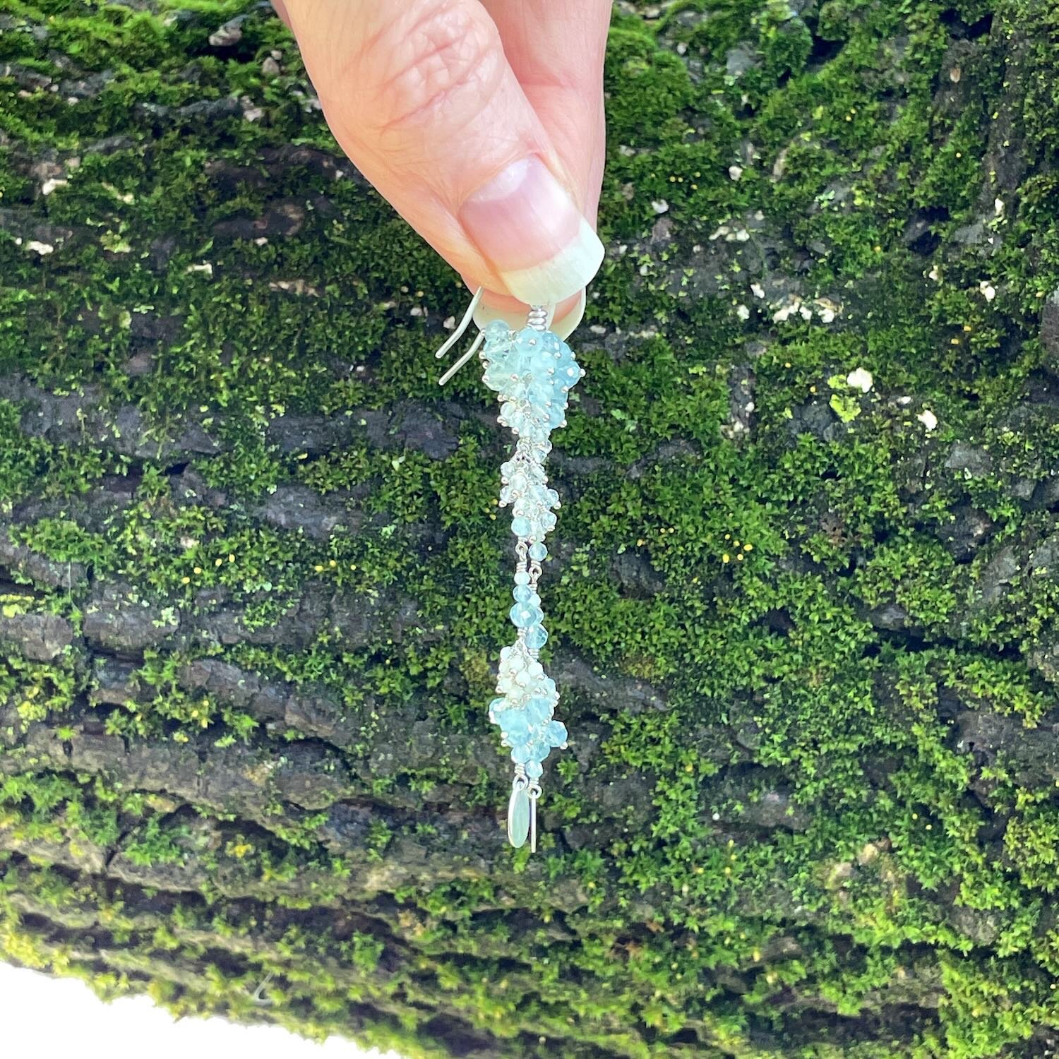 Long sterling silver earrings with clusters of light blue aquamarine, off white opals and clear quartz gemstone beads.
