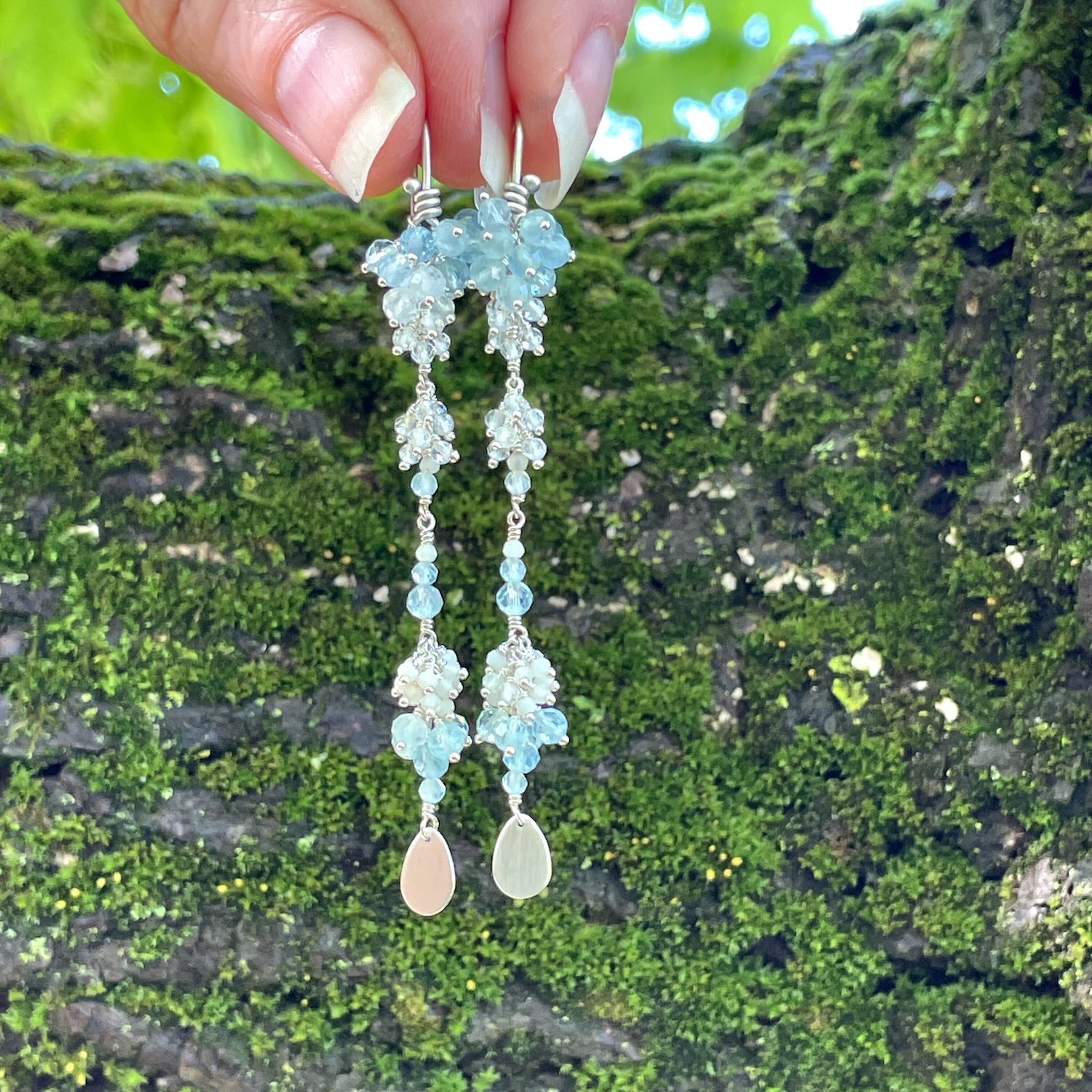 Long sterling silver earrings with clusters of light blue aquamarine, off white opals and clear quartz gemstone beads.