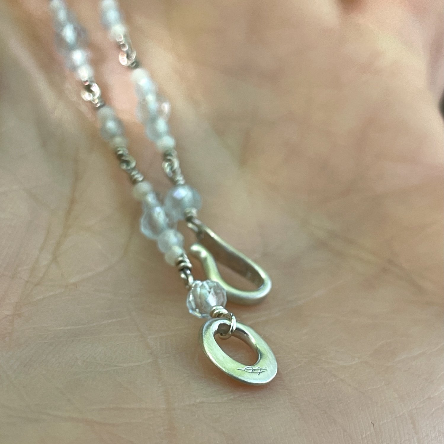 Satin finish sterling silver hook and eye clasp with artist signature.