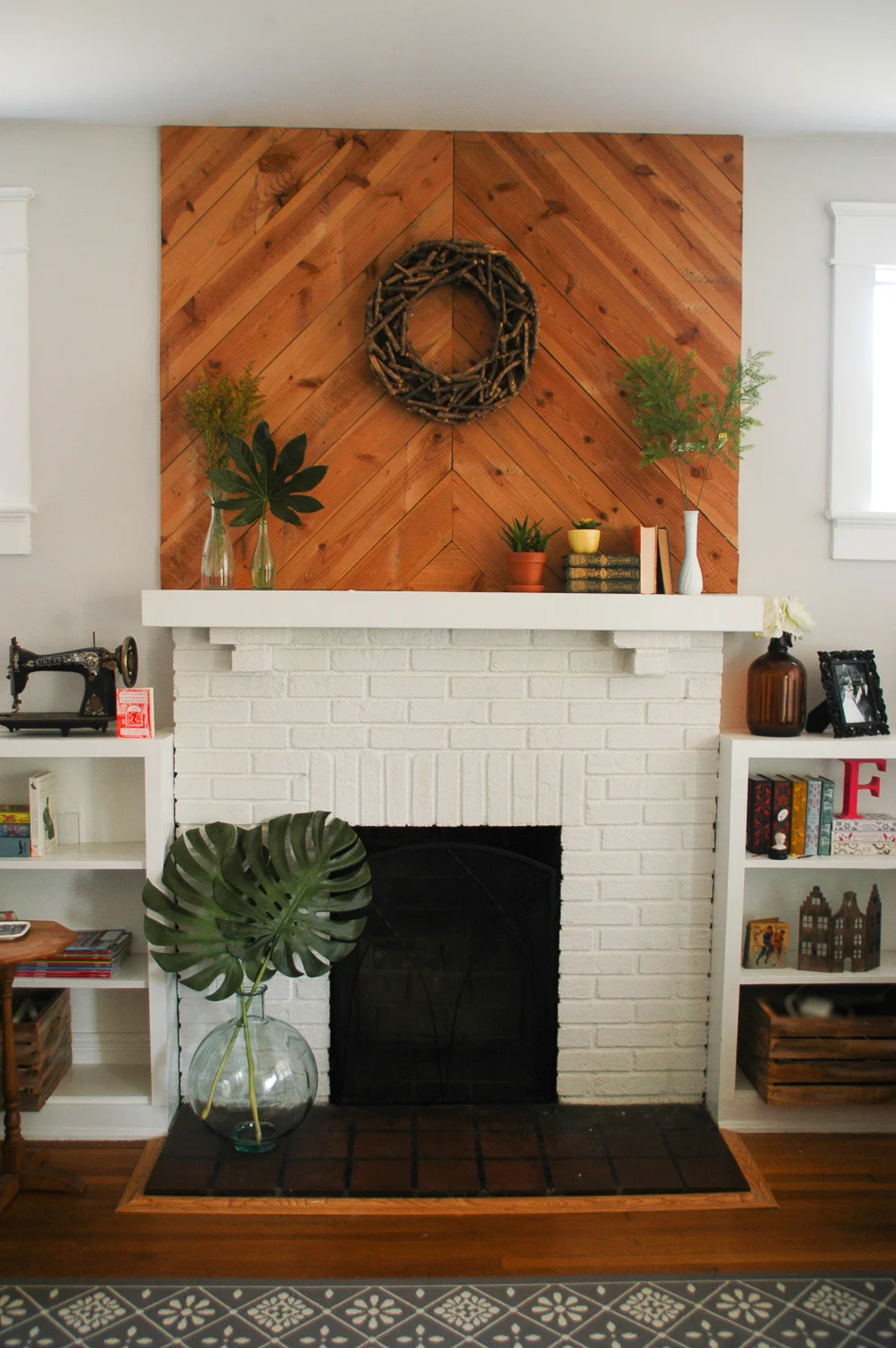 We added these wood slats to the fireplace to create some texture and height. Bonus: it didn't cost us anything! We had some old wiring that needed to be removed in the attic, and had to rip up a bunch of boards to get to them. Instead of throwing it all away, we just reused it inside the house! How's that for recycling? 