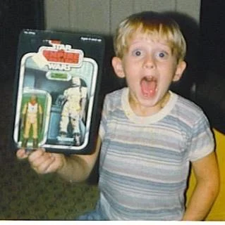 The author as a boy receiving Bossk the Bounty Hunter, the same look he has the first time seeing any new Star Wars film in the theater.