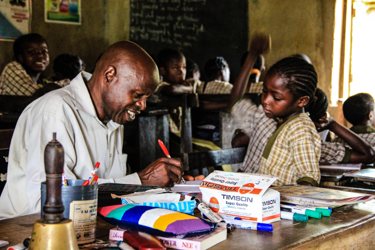   Teacher Philip, from Elekuru Community School, lovingly grading one of his student&rsquo;s papers. &ldquo;It brings me great joy to teach,&rdquo; says Philip.&nbsp;  