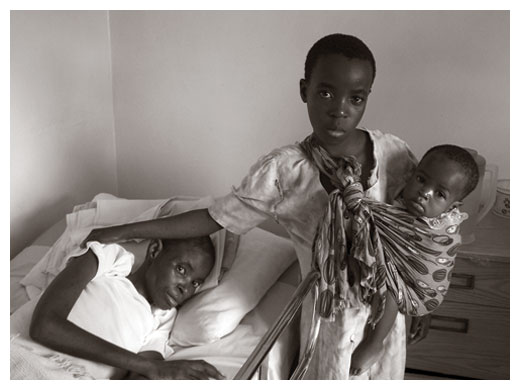 A child carrying her sibling and visiting her sick mother in a clinic near Kabwe, Zambia.