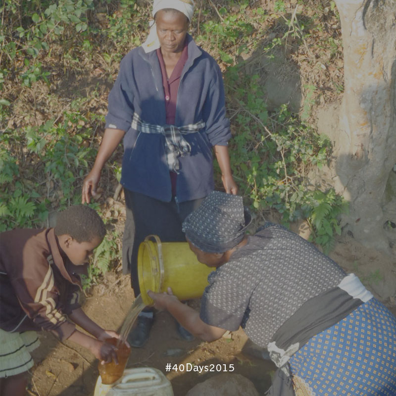 Care Workers in Swaziland help a young girl fetch water