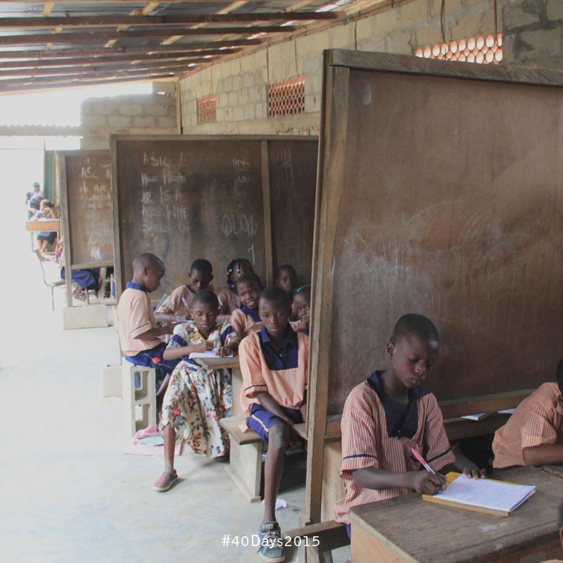 Many grades are taught, separated by chalkboards, in Nigeria