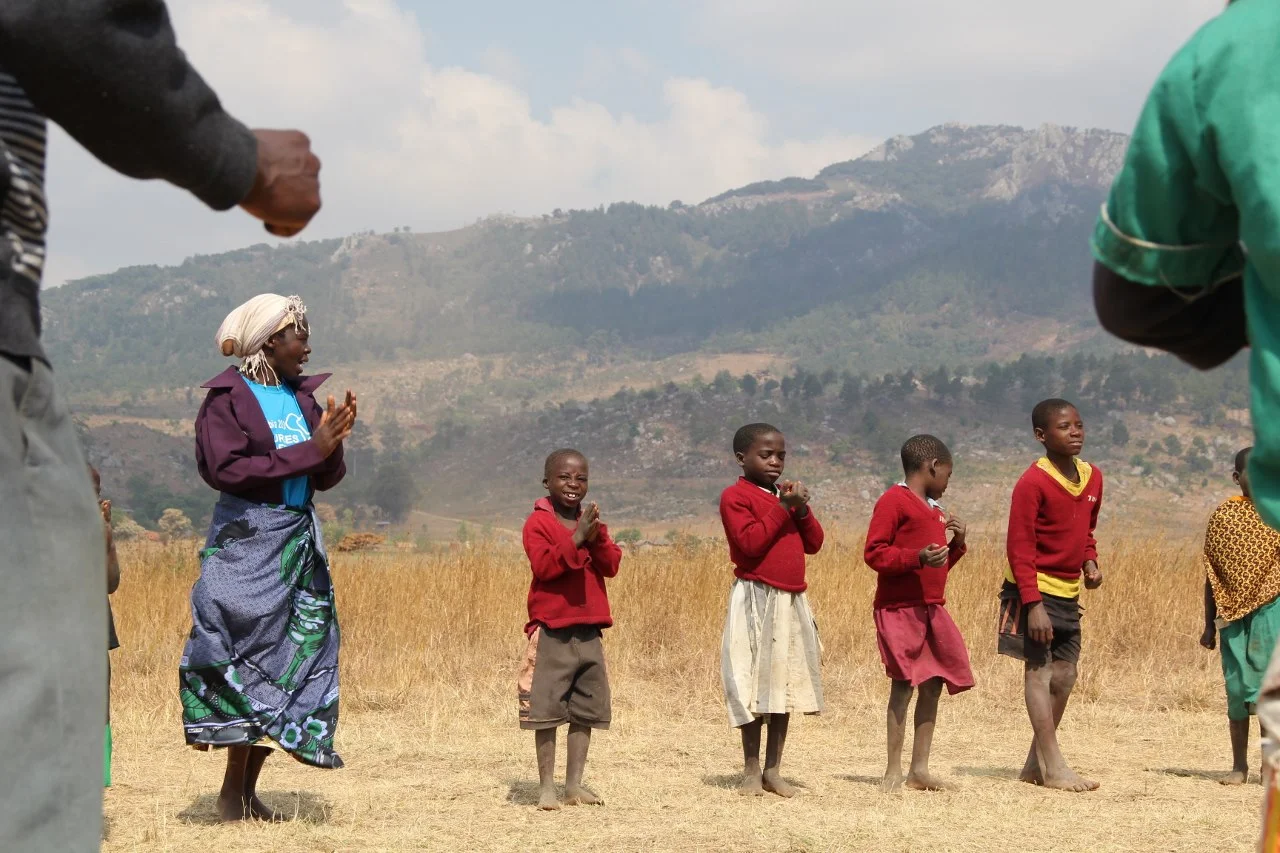 Violet playing with children and Care Workers in Mngwere
