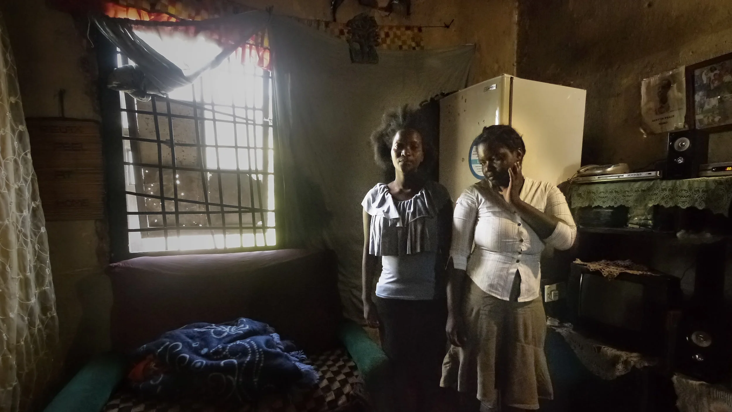 These sisters, both struggling in difficult circumstances, live together to support one other. One sister has a 12-week-old baby and the other recently lost her husband. They both struggle to support the children in their care. With chalk, one child left a note behind the door that says “I ❤ u father”.