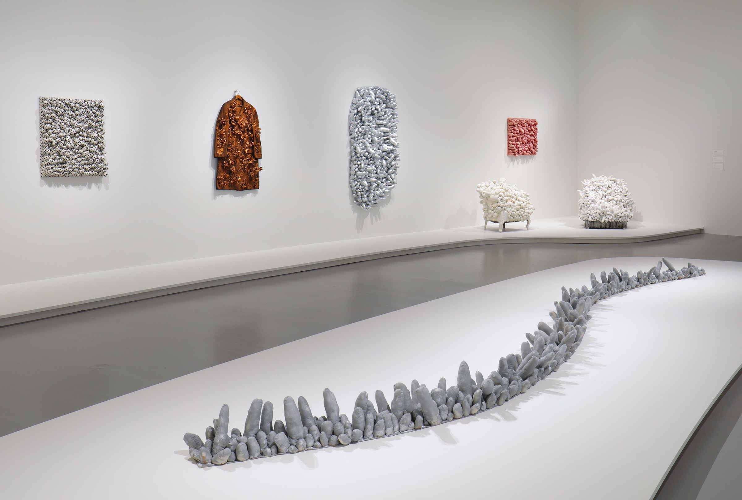 Installation view of Yayoi Kusama: Infinity Mirrors at the Hirshhorn Museum and Sculpture Garden, 2017. Left to right: Blue Spots, 1965; Flowers – Overcoat, 1964; A Snake, 1974; Ennui, 1976; Accumulation, 1962-64; Red Stripes, 1965; Arm Chair, 1963 Photo by Cathy Carver