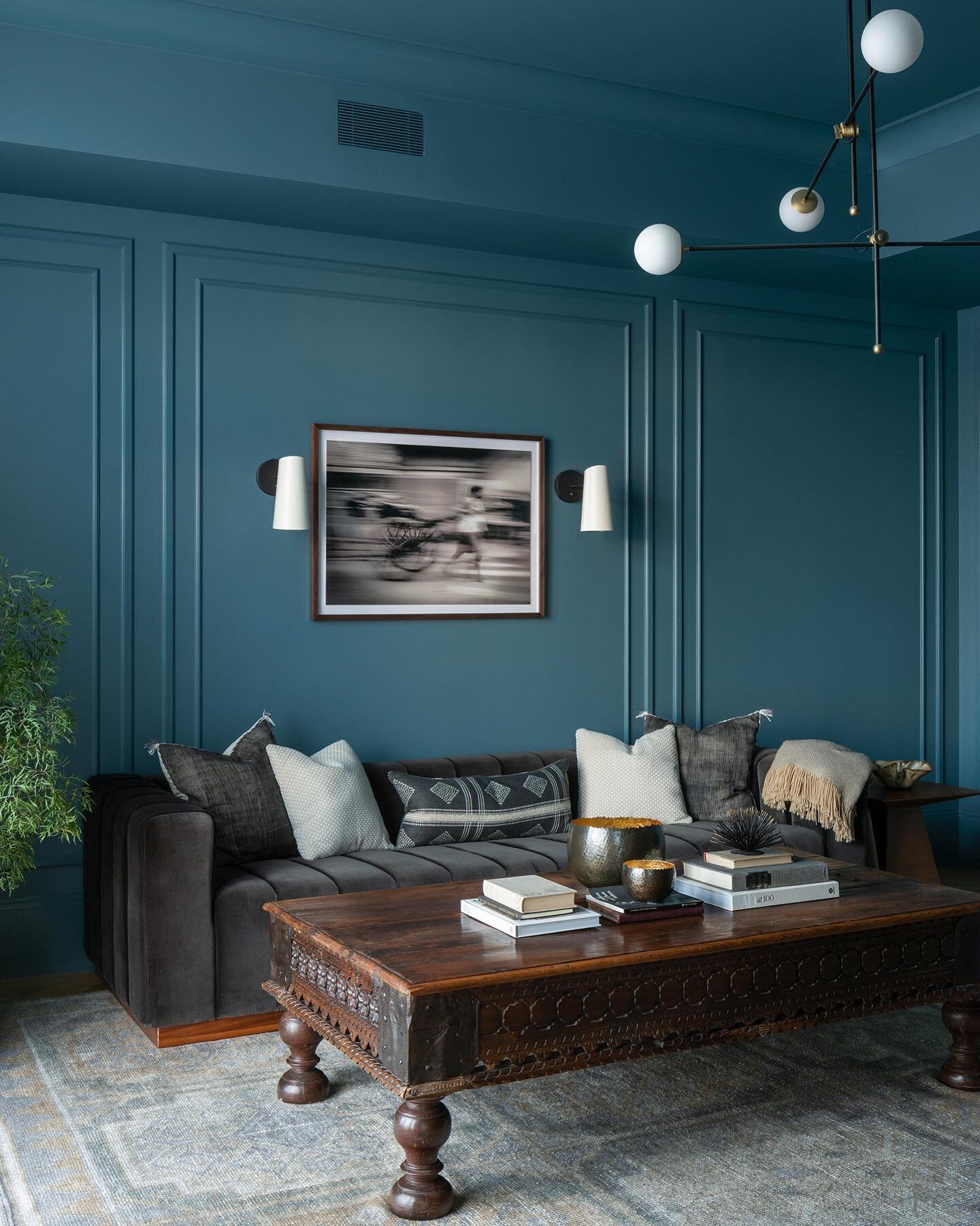 A serene study immersed in a blue hue &ndash; this room exudes a tranquil ambiance, where this antique repurposed bed from India takes center stage as a unique coffee table. Its rich history and intricate details beautifully contrast with the modern 