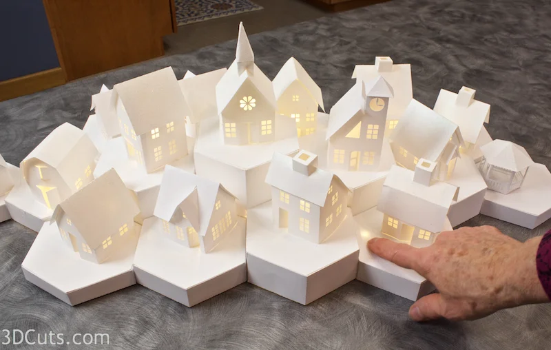 Stunning 3D illuminated tea light village by Marji Roy of 3dcuts.com. SVG, PDF, PNG and DXF cutting files and complete tutorials available.