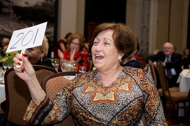 St. Charles Mayor Sally Faith bids on directing the chorus for a song onstage.