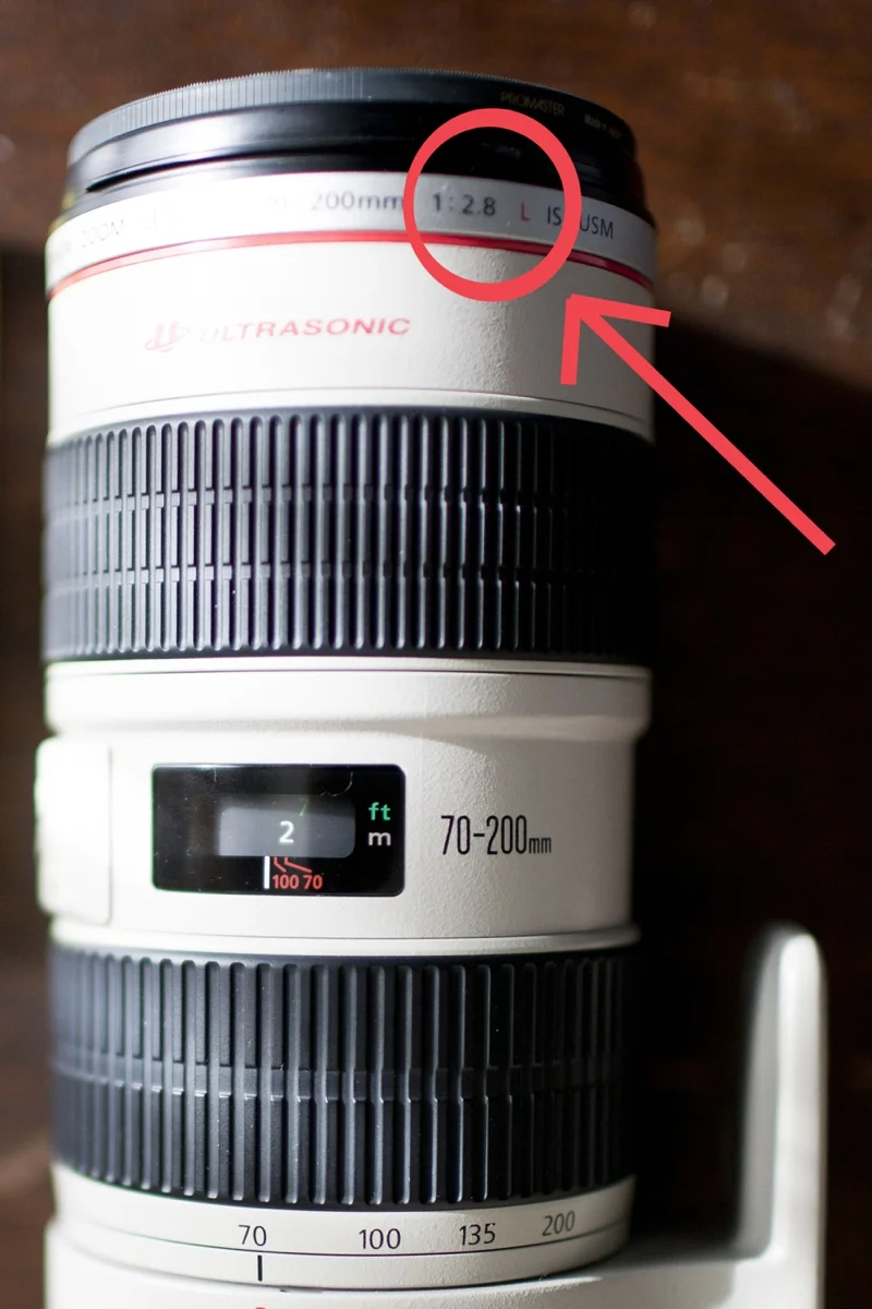 After your lens' size (aka ##mm) you will see this ratio, and the number after the colon is the widest your lens opens. So in the case of my 70-200mm lens it is 2.8
